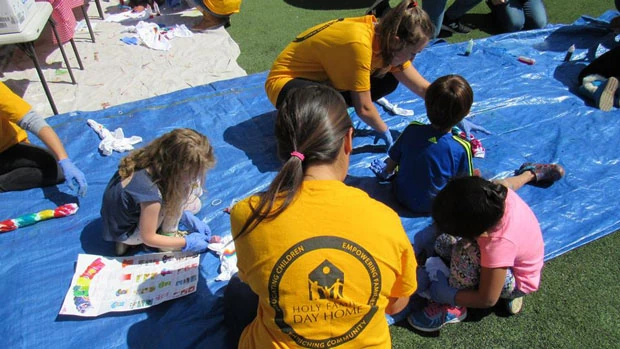 "Volunteers playing with children" Photo courtesy of Holy Family Day Home